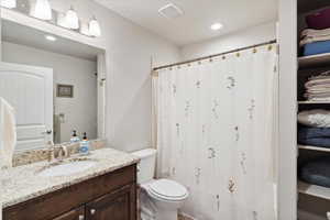 Bathroom featuring toilet, vanity, recessed lighting, and a shower with shower curtain