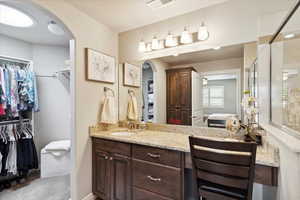 Bathroom featuring a walk in closet, a shower stall, vanity, and connected bathroom