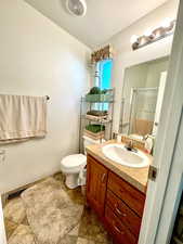 Bathroom featuring vanity, toilet, a textured ceiling, visible vents, and a stall shower