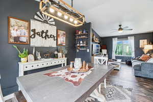 Dining room with a ceiling fan, wood finished floors, vaulted ceiling, and baseboards