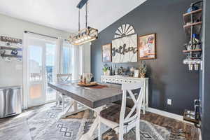 Dining room featuring a chandelier, wood finished floors, baseboards, and a textured ceiling