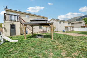Rear view of house featuring a fire pit, a gazebo, and a mountain view
