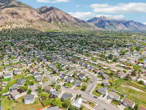 Aerial view of property and surrounding area with mountains and nearby suburban area