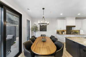 Dining area featuring light wood-type flooring, a chandelier, and recessed lighting