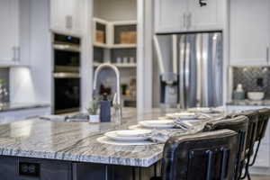 Kitchen featuring appliances with stainless steel finishes, white cabinetry, and a kitchen island