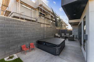 View of patio / terrace with a hot tub, a fenced backyard, and an outdoor living space