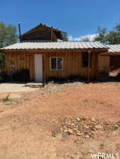 View of front of house with metal roof and board and batten siding
