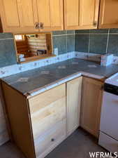 Kitchen featuring stove, tasteful backsplash, and tile countertops