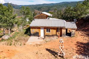 View of front facade with board and batten siding, a mountain view, and metal roof