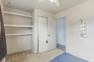 Unfurnished bedroom featuring carpet floors, a closet, and a ceiling fan