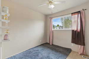 Spare room featuring carpet floors and ceiling fan