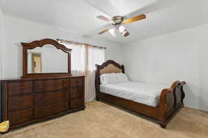 Bedroom with light colored carpet and a ceiling fan