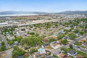 Aerial view of property and surrounding area featuring a water and mountain view and nearby suburban area