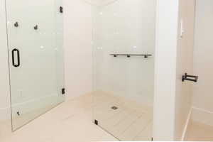 Full bath with a stall shower and tile patterned flooring