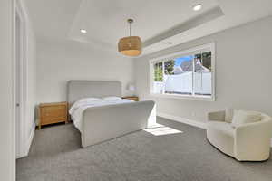Bedroom with a raised ceiling, carpet floors, and recessed lighting