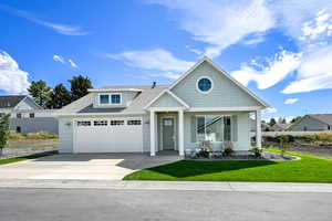 View of front facade with roof with shingles, driveway, and a front yard
