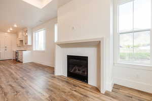 Unfurnished living room featuring light wood-style flooring, plenty of natural light, baseboards, and recessed lighting