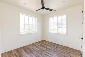 Unfurnished room featuring baseboards, wood finished floors, and ceiling fan
