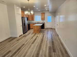 Kitchen featuring stainless steel fridge, a chandelier, recessed lighting, baseboards, and light wood-style flooring