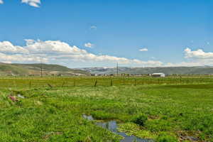 View of yard featuring a rural view, fence, and a mountain view