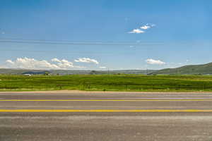 View of asphalt road featuring a view of countryside and a mountain view