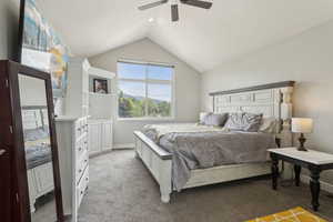 Bedroom featuring lofted ceiling, light carpet, a ceiling fan, and baseboards
