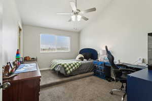 Bedroom with carpet floors, an office area, vaulted ceiling, baseboards, and a ceiling fan
