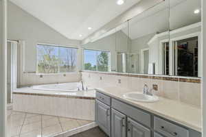 Bathroom with vaulted ceiling, a shower stall, vanity, recessed lighting, and a bath