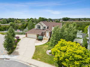 View of front of home with driveway, brick siding, and an attached garage