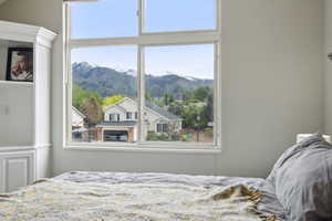 Bedroom featuring a mountain view and multiple windows