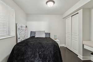 Bedroom featuring concrete flooring, a closet, and a textured ceiling