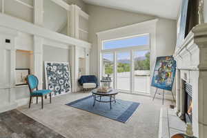 Living area featuring a premium fireplace and high vaulted ceiling