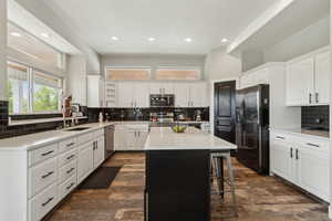 Kitchen with appliances with stainless steel finishes, a sink, tasteful backsplash, recessed lighting, and a kitchen island