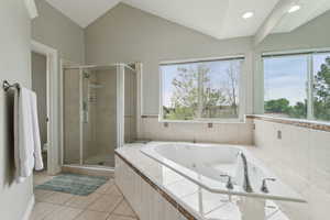 Bathroom with a stall shower, tile patterned floors, toilet, a jetted tub, and lofted ceiling