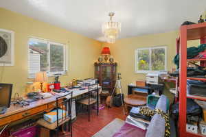 Office space with wood finished floors and a chandelier