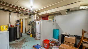 Unfinished basement featuring water heater and a water softener system