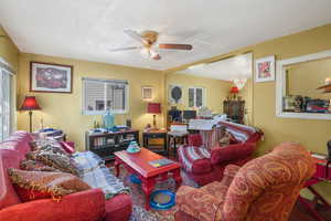 Living area with ceiling fan and a textured ceiling