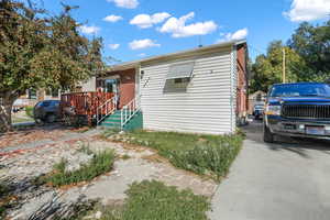 View of front facade featuring a wooden deck and fence