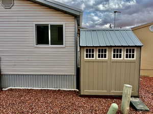 View of home's exterior with a storage shed, an outbuilding, and metal roof
