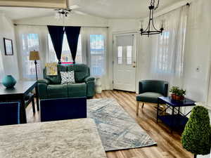 Living area with wood finished floors, a chandelier, and a ceiling fan