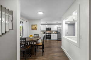 Dining area featuring dark wood-style flooring and stairway