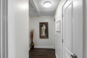 Hall featuring dark wood-style floors and baseboards