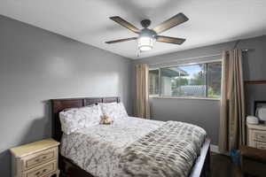 Bedroom with dark wood-style floors and ceiling fan