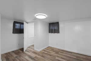 Finished basement with wood finished floors and baseboards