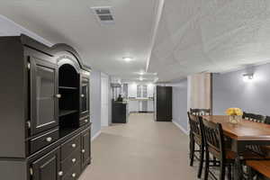 Dining room with a textured ceiling and baseboards