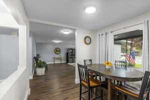 Dining space with baseboards and dark wood-style flooring