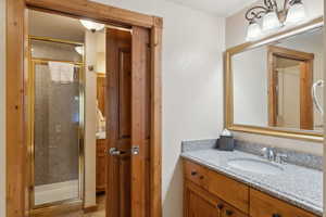 Bathroom featuring a shower stall and vanity