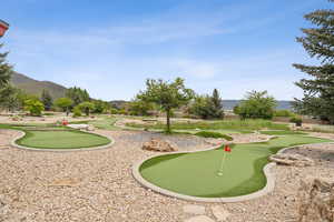 View of property's community featuring an area to practice putting and a mountain view