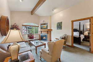 Carpeted living area featuring a fireplace and baseboards