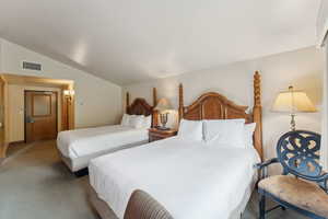 Bedroom featuring lofted ceiling and carpet